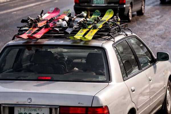 屋根にスキー板を載せた自動車のイメージ。