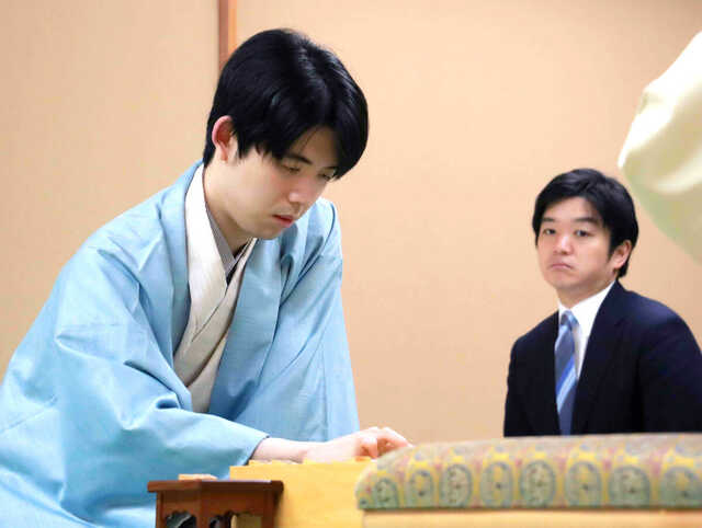 名人戦第３局に勝利した藤井聡太名人（左、奥は副立会の村山慈明八段）（日本将棋連盟提供）